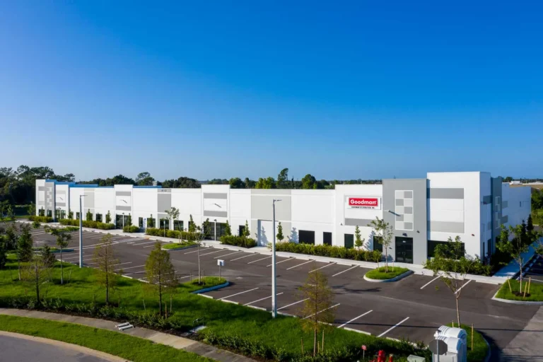 An aerial view of Goodman, a large white building with a nice large parking lot