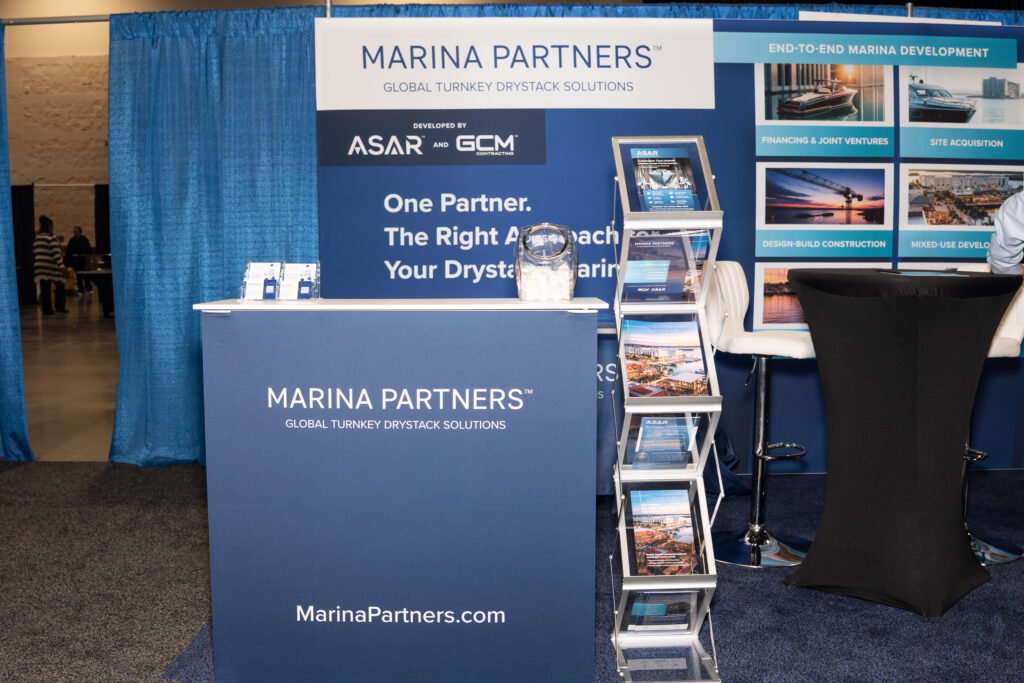 Marina partners networking at the trade show, discussing collaboration and industry trends in a professional setting.