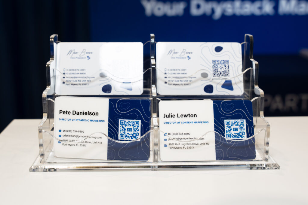 A display case featuring four neatly arranged business cards, showcasing various designs and contact information.