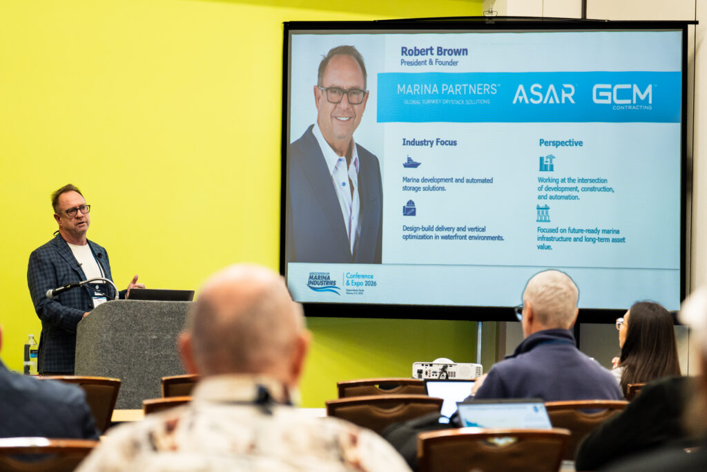 Robert Brown is giving a presentation at a conference, actively engaging with the audience in attendance.