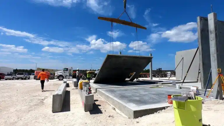 Concrete being laid in the middle of a construction site with bright blue skies
